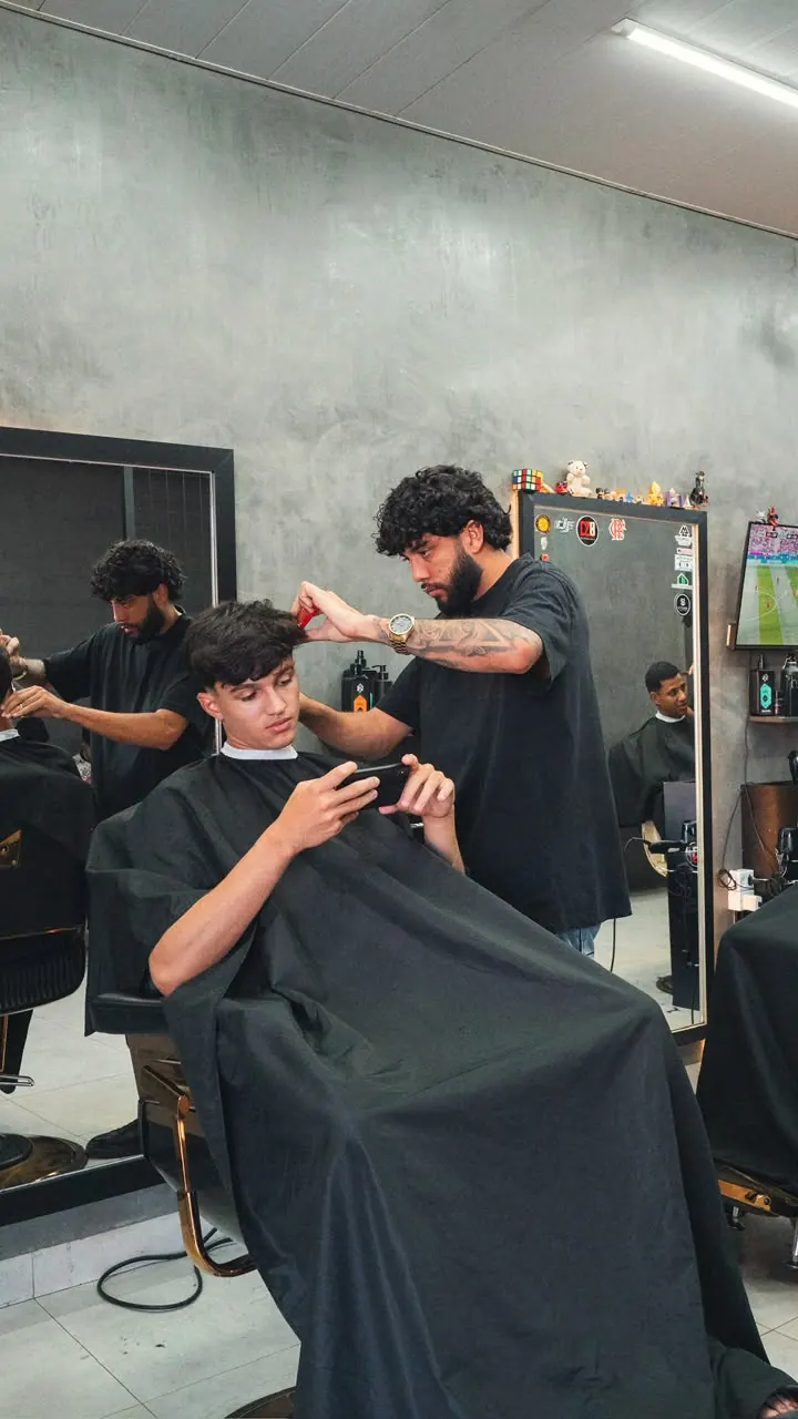 Barbeiro cortando o cabelo de cliente na DZ8