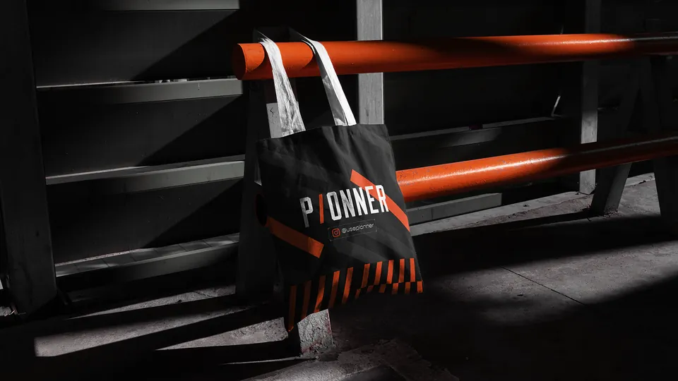 Ecobag preta com logotipo pendurada em corrimão laranja